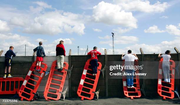 Liverpool fans use roadworks barriers to get a glimpse of the Liverpool team training session ahead of the Champions League Semi Final Second Leg...