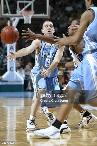 Brian Morrison of North Carolina passes against the defense of Jason Williams of Duke during the ACC Tournament game at the Charlotte Coliseum in...
