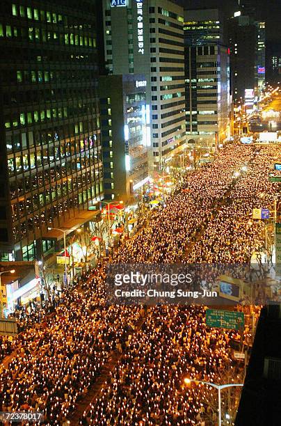 South Korean protesters hold candles during a rally in downtown Seoul, on March 27, 2004 in Seoul, South Korea. Thousands of South Koreans held their...