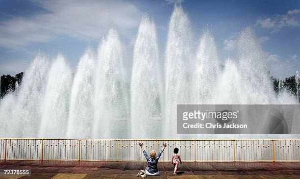 Lady and her granddaughter enjoy the hot weather in front fountains in Battersea Park May 27 London, England. The sunshine has been forecast to...