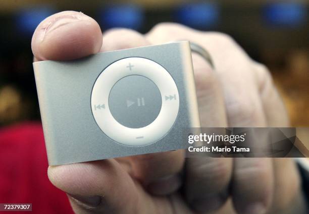 An employee holds the new iPod shuffle, which went on sale today, in the Apple Store Fifth Avenue November 3, 2006 in New York City. The device costs...