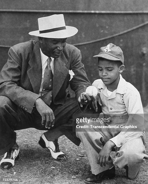Martin Dihigo, kneeling with a young Almendares fan, discusses pitching in this 1942 meeting in Havana.