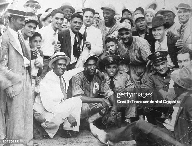 Martin Dihigo, center kneeling, pitcher and outfielder for Almendares Baseball Club posese with fans and teammates after a game in 1930 in Havana.