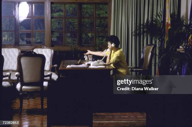 Philippine President Corazon Aquino in her office, on the phone.