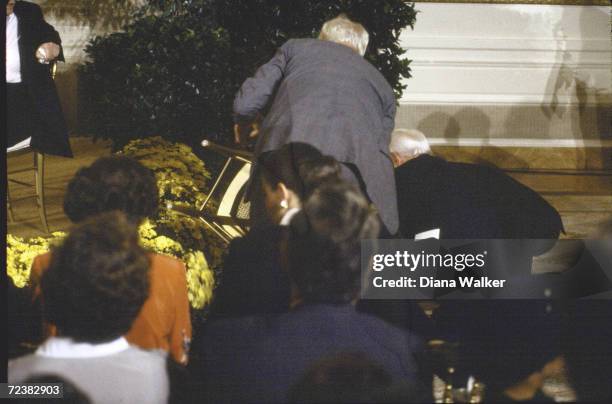 Pianist Vladimir Horowitz helping nancy Reagan to her feet after she fell off stage, at WH.