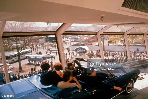 Family riding in the new Ford Mustang at the Ford Motor Company's World's Fair exhibit.