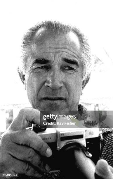 Photographer David Douglas Duncan holding camera.