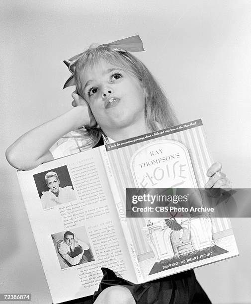 Promotional portrait of American child actress Evelyn Rudie, her head tossed back, as she holds a copy of the book 'Elosie,' in support of her role...