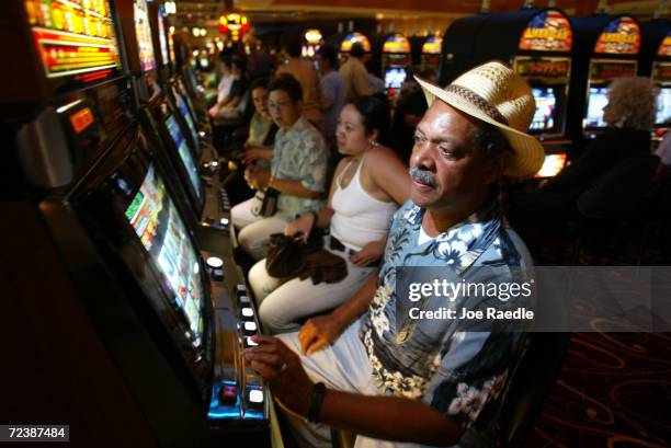 Hugh Salmon and Nada Salmon play slot machines May 11, 2004 during the grand opening for the Seminole Hard Rock Hotel and Casino in Hollywood,...
