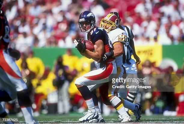 Wide receiver Ed McCaffrey of the Denver Broncos in action against linebacker Derek Smith of the Washington Redskins during the game at the Jack Kent...
