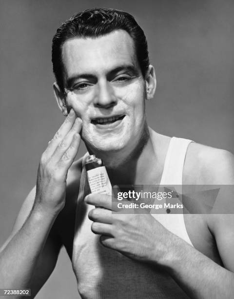 1950s: Man applying lotion.
