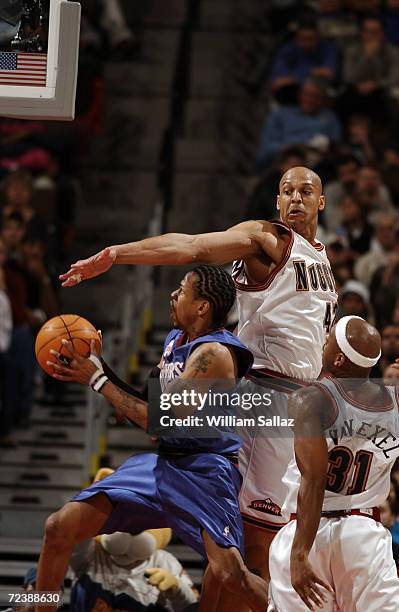 Guard Allen Iverson of the Philadelphia 76ers shoots past forward Scott Williams of the Denver Nuggets during the NBA game at the Pepsi Center in...