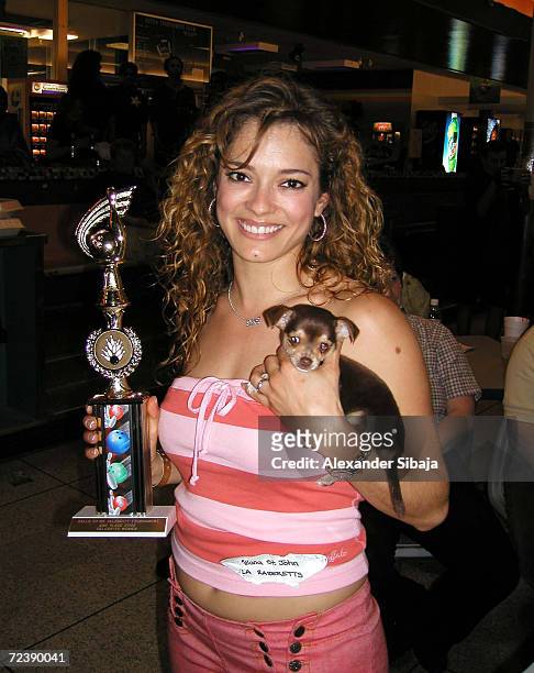 Former Los Angeles Raiders cheerleader Allana St. John holds her trophy and a puppy chihuahua at the Celebrity Bowling Classic to benefit the...