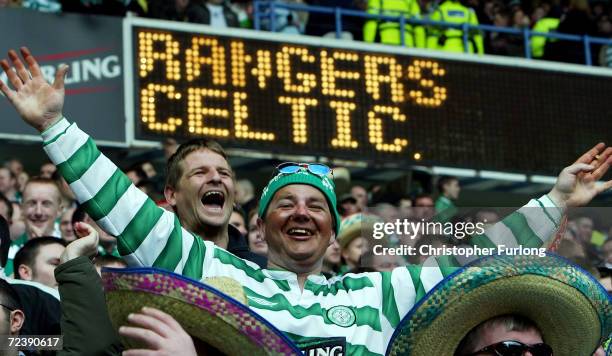 Celtic fans cheer on their team during the Scottish premier league match between Rangers and Celtic at Ibrox Stadium on March 28, 2004 in Glasgow,...