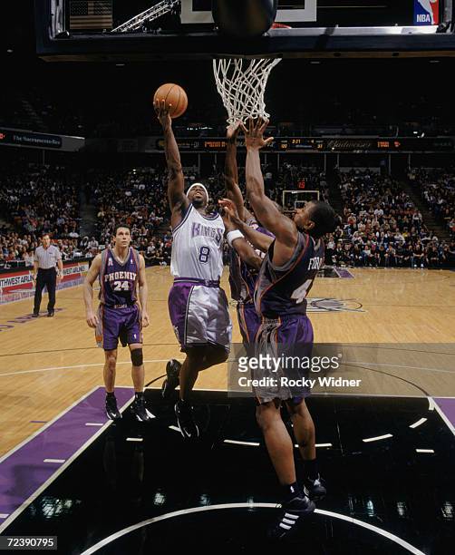 Poin tguard Mateen Cleaves of the Sacramento Kings shoots over forward Alton Ford of the Phoenix Suns during the NBA game at Arco Arena in...