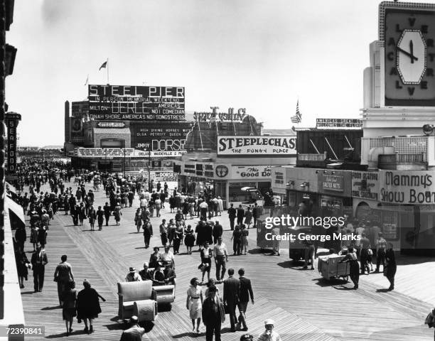 1950s: Sea-side board-walk scene.