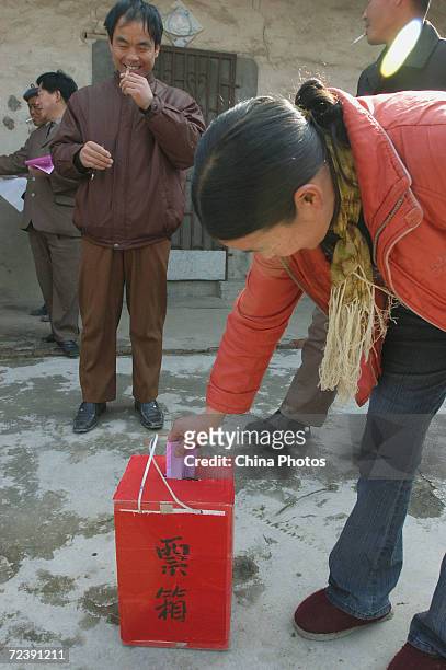 Villager puts her vote into a ballot box of an mobile polling station in front of her home at Fengxing Village on March 18, 2005 in Fanchang County...