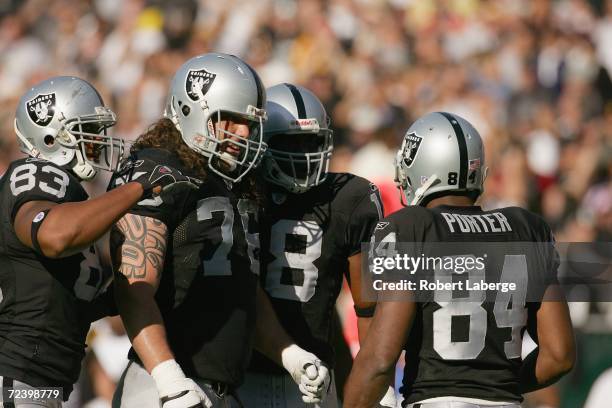 Tight end Courtney Anderson, tackle Robert Gallery, wide receivers Randy Moss and Jerry Porter of the Oakland Raiders celebrate on the field during...