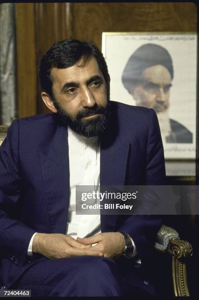 Iranian Foreign Minister being interviewed about the UN mediated efforts to end the Iran-Irafq war with portrait of Ayatullah Khomeiniin in the...