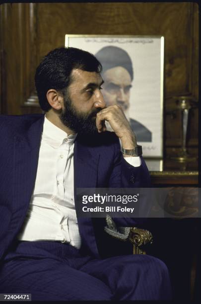 Iranian Foreign Minister being interviewed about the UN mediated efforts to end the Iran-Irafq war with portrait of Ayatullah Khomeiniin in the...