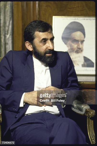 Iranian Foreign Minister being interviewed about the UN mediated efforts to end the Iran-Irafq war with portrait of Ayatullah Khomeiniin in the...