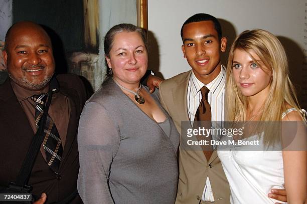 Footballer Theo Walcot with his parents and guest Melanie Slade attend the gala opening of the Exceptional Youth Exhibition hosted by Teen Vogue's...