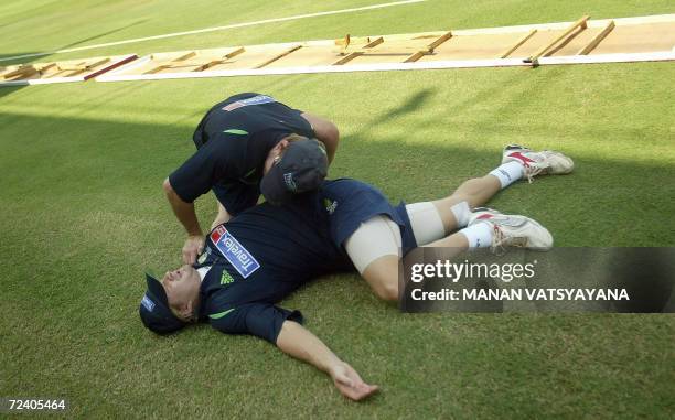 Australian cricketer Shane Watson assisted by a team official as he stretches during a practice session in Mumbai, 04 November 2006. Australia will...