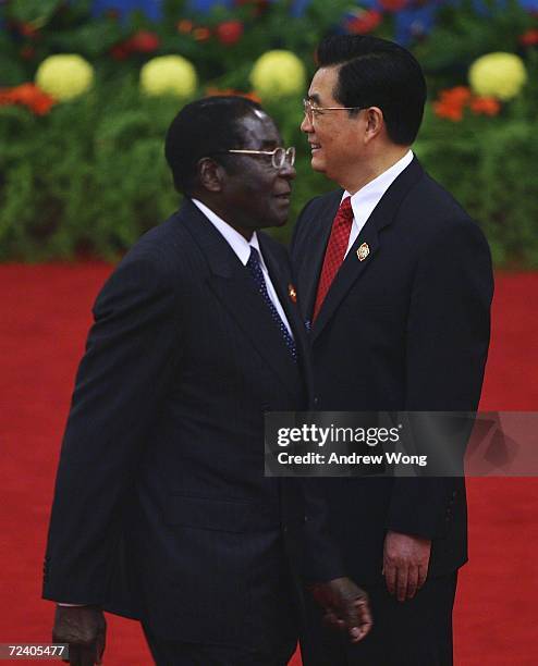 Zimbabwean President Robert Mugabe walks past Chinese President Hu Jintao during the welcoming ceremony for representatives attending the Beijing...