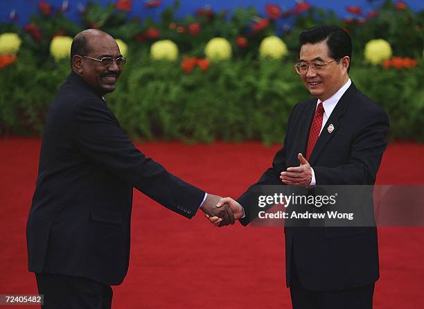 Sudanese President Omar al-Beshir is greeted by Chinese President Hu Jintao during the welcoming ceremony for representatives attending the Beijing...