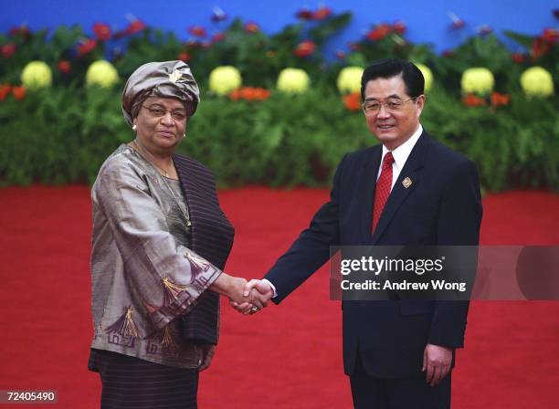 Liberian President Ellen Johnson Sirleaf is greeted by Chinese President Hu Jintao during the welcoming ceremony for representatives attending the...