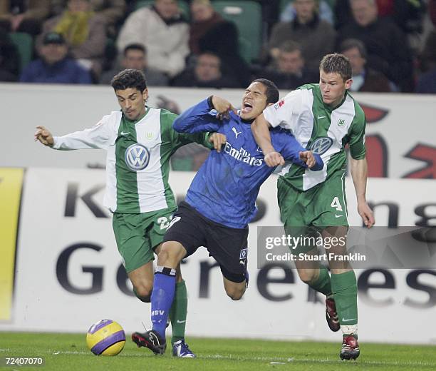 Paolo Guerrero of Hamburg is challenged by Alex and Alexander Madlung of Wolfsburg during the Bundesliga match between VfL Wolfsburg and Hamburger SV...