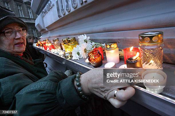 An elderly Hungarian woman places a candle in front of the House of Terror, former headquarters of the communist secret police which has been...