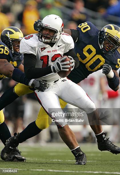 Defensive ends Tim Jamison and LaMarr Woodley of the Michigan Wolverines sack quarterback Nate Davis of the Ball State Cardinals for a loss of five...