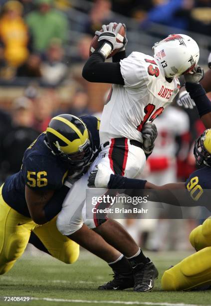 Defensive ends Tim Jamison and LaMarr Woodley of the Michigan Wolverines sack quarterback Nate Davis of the Ball State Cardinals for a loss of five...