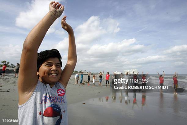 Jonathan Chan raises his arms as he joins other people participating in a Greenpeace event to protest against global warming at a beach in Dania,...