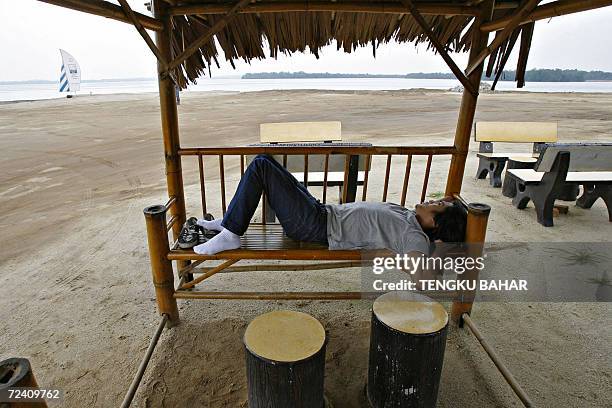 Malaysia-economy-property A Johorean youth sleeps at a covered bench at Danga Bay, part of the planned Southern Johor Economic Region, in Johor Baru,...