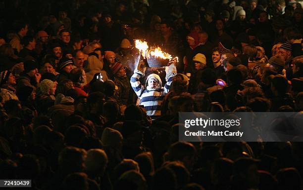 Woman runs through the crowds with a burrning barrel soaked in tar on November 4 2006 in Devon, England. The 400-year-old event at Ottery St Mary's...