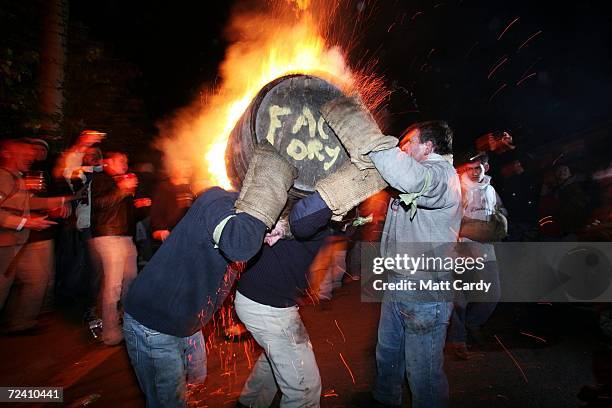 Man is loaded with a burrning barrel soaked in tar on November 4 2006 in Devon, England. The 400-year-old event at Ottery St Mary's carnival on 4...