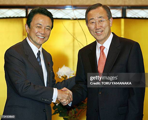 South Korean Foreign Minister Ban Ki-Moon is welcomed by his Japanese counterpart Taro Aso prior to their meeting at a Japanese restaurant in Tokyo,...
