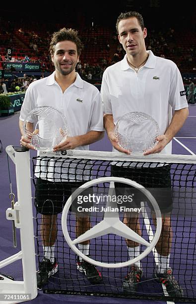 Arnaud Clement and Michael Llodra of France pose for a photo with their trophies after defeating Fabrice Santoro of France and Nenad Zimonjic of...