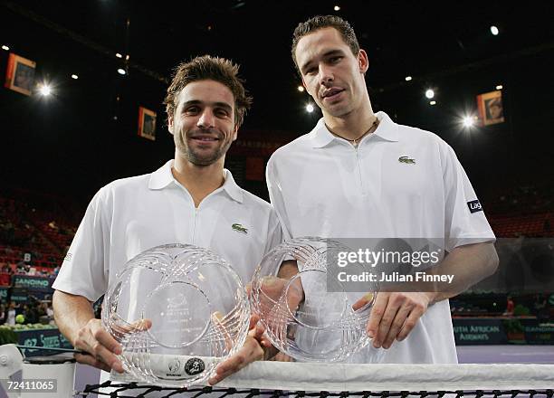 Arnaud Clement and Michael Llodra of France pose for a photo with their trophies after defeating Fabrice Santoro of France and Nenad Zimonjic of...