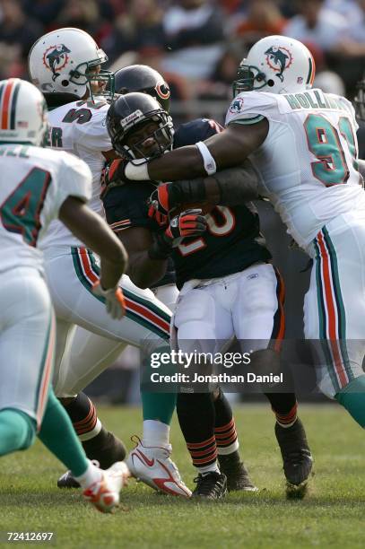 Thomas Jones of the Chicago Bears gets stopped by Vonnie Holliday of the Miami Dolphins during a game on November 5, 2006 at Soldier Field in...