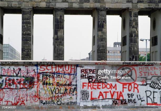Graffiti, including Freedom for Latvia, on Berlin Wall at Brandenberg Gate, Berlin, Germany.