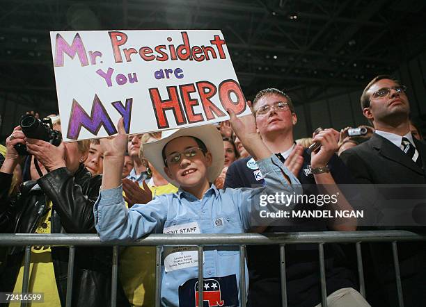 Topeka, UNITED STATES: A young fan holds a placard showing his support of US President George W. Bush as he speaks during a campaign rally at the...