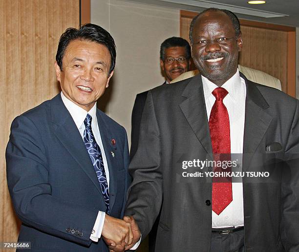 Sudanese Foreign Minister Lam Akol shakes hands with his Japanese counterpart Taro Aso prior to their talks at Aso's office in Tokyo, 06 November...