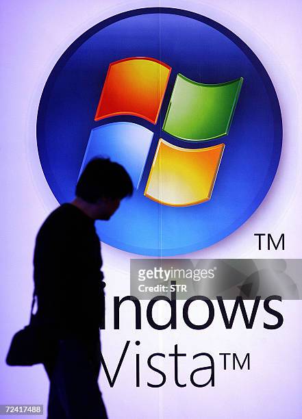 Passerby walks by a billboard for Microsoft's new software, Windows Vista, during the launch in Beijing 06 November 2006. Microsoft announced...