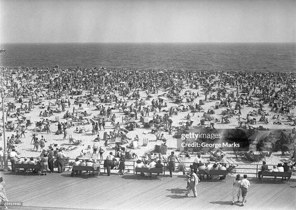 Crowd of people on beach, (B&W), elevated view