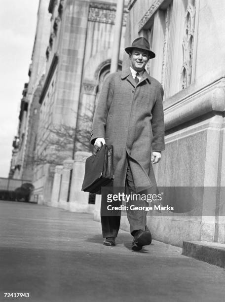 hombre en abrigo y sombrero caminar sobre la acera, (b & p), - george marks man fotografías e imágenes de stock