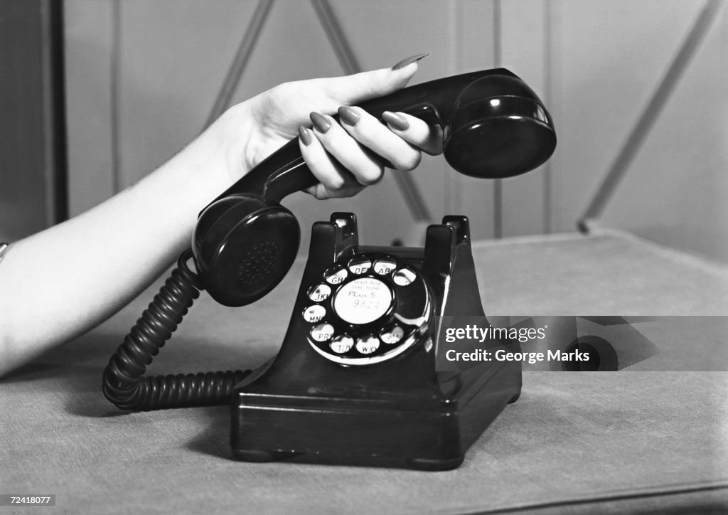 Woman picking up phone, (close up of hand), (B&W)