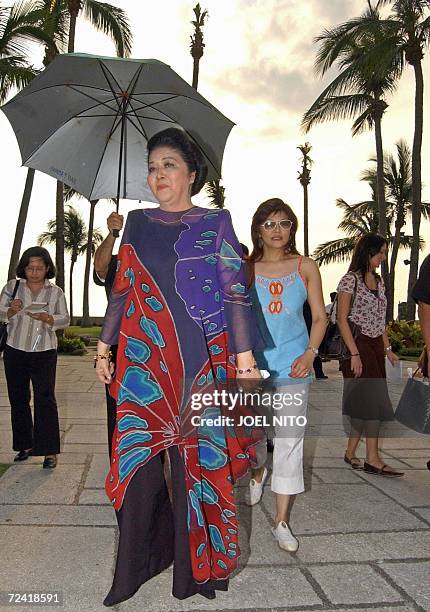 Former Philippines first lady Imelda Marcos with her daughter Imee Marcos moves to another location as she takes part in a photo shoot beside the...